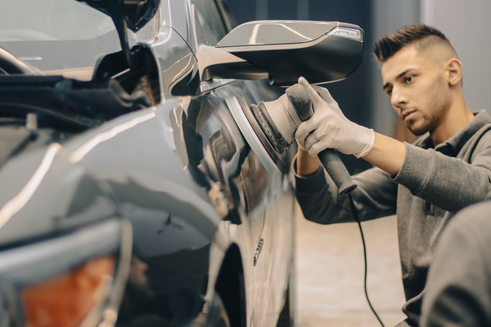 Technician polishing a car panel